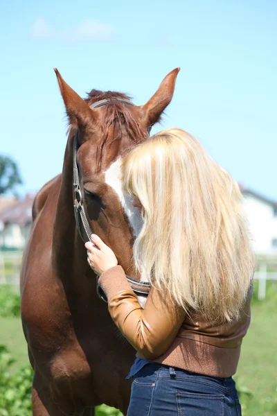 Blond kobieta i kasztanów horse — Zdjęcie stockowe