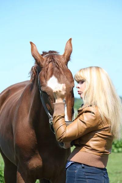 Blond kobieta i kasztanów horse — Zdjęcie stockowe