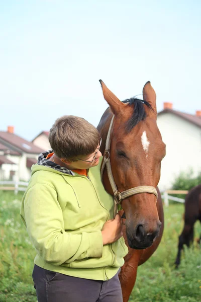 Adolescent souriant avec des chevaux sur le terrain — Photo