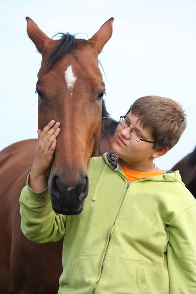 Χαμογελώντας έφηβο αγόρι με άλογα στο πεδίο — Φωτογραφία Αρχείου