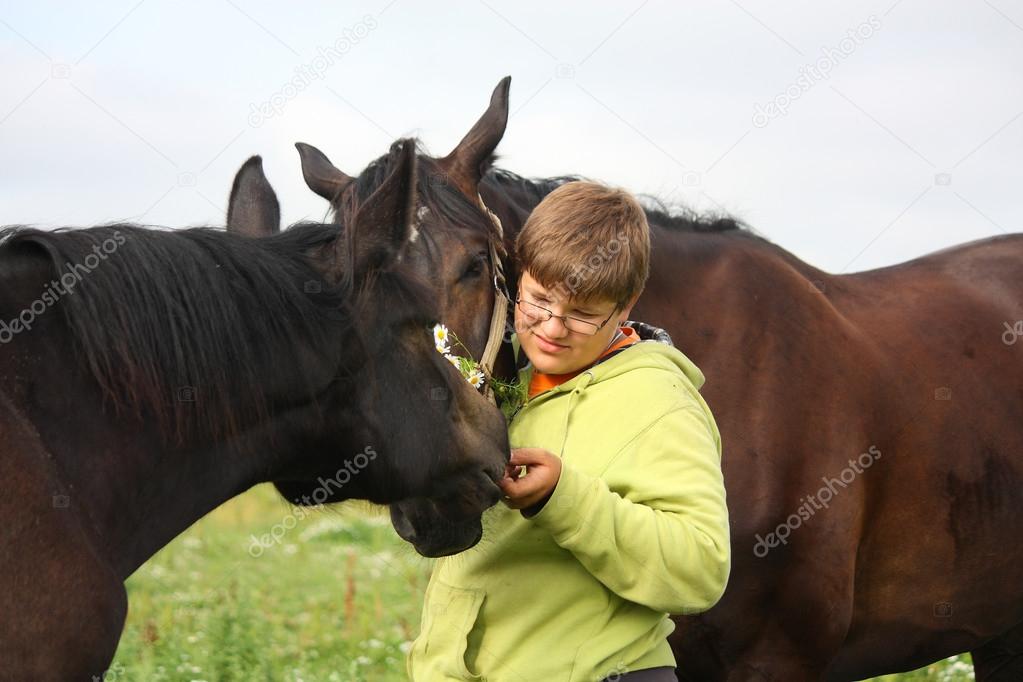 Teenager boy and horses from the herd