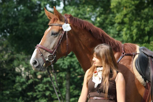 Schönes Mädchen in Kleid und Pferdeporträt in der Nähe des Blumenbeetes — Stockfoto