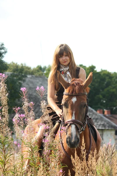 Bella ragazza adolescente a cavallo al campo di fiori — Foto Stock