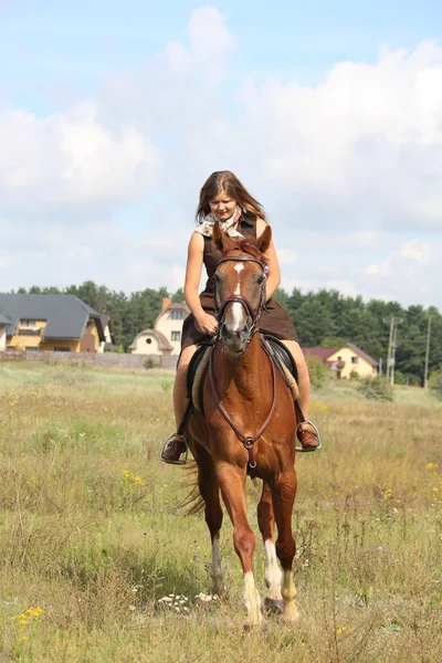 Beautiful teenage girl riding horse at the field — Stock Photo, Image