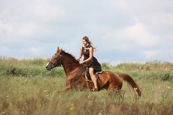 Beautiful teenage girl riding horse at the field — Stock Photo, Image