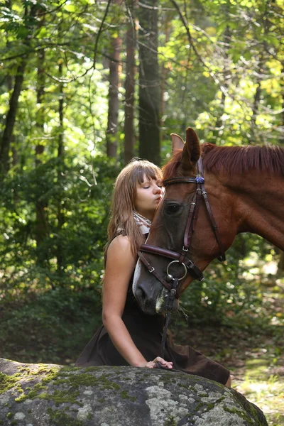 Hermosa chica y retrato de caballo marrón en el bosque misterioso — Foto de Stock