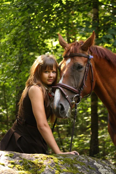 Piękna dziewczyna i brązowy koń portret w tajemniczym lesie — Zdjęcie stockowe