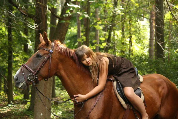 Mädchen in Kleid und braunem Pferdeporträt im Wald — Stockfoto