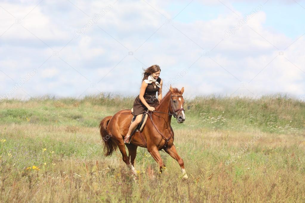 Beautiful teenage girl riding horse at the field