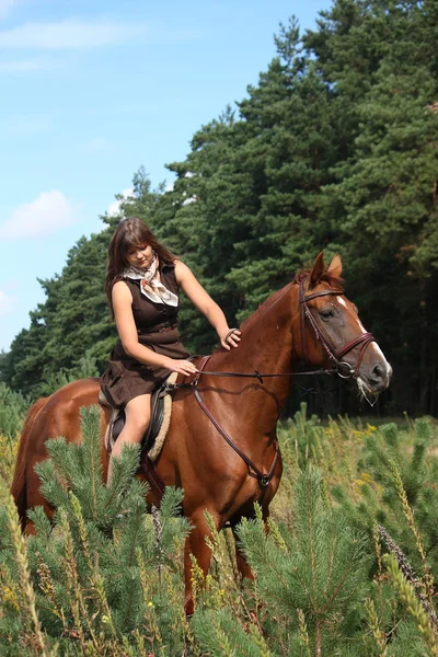 Dziewczynę w strój i brązowy koń portret w lesie — Zdjęcie stockowe