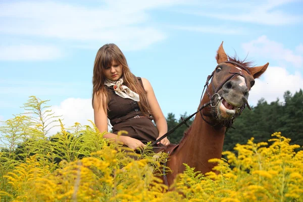 꽃의 분야에서 말을 타고 아름 다운 십 대 소녀 — 스톡 사진