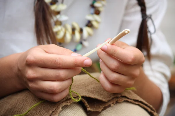 Primo piano della giovane donna che lavora a maglia con aghi ossei — Foto Stock