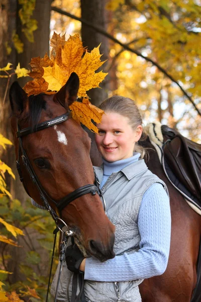 Hermosa mujer rubia y caballo marrón — Foto de Stock