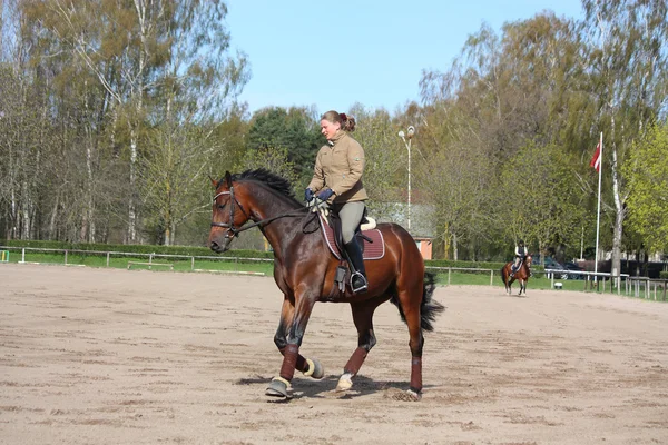 Mulher loira montando cavalo de baía — Fotografia de Stock