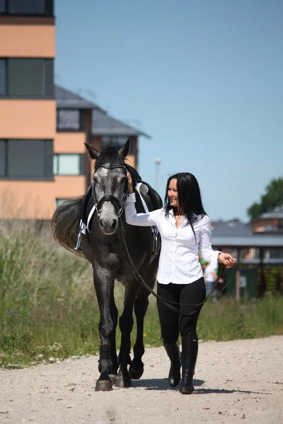 Beautiful caucasian young woman and horse walking — Stock Photo, Image