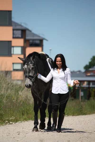 Beautiful caucasian young woman and horse walking — Stock Photo, Image