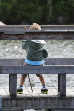 bir göl oturan çocuk