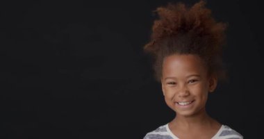 Mutlu gülümseyen Afro-Amerikalı kız karanlık arka planda