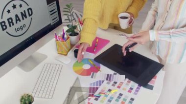 Grafik tasarımcıları ofiste projeyi tartışıyor