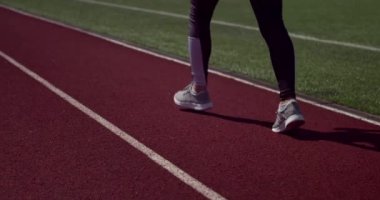 Stadyumda koşan genç bir bayan.