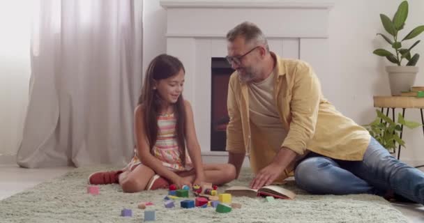 Volwassen Man Zijn Kleine Kleindochter Lezen Boek Spelen Thuis — Stockvideo