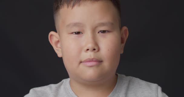 暗い背景にアジアの少年を投げ クローズアップ — ストック動画