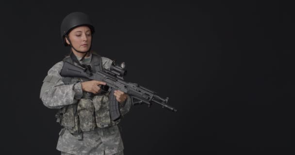 黒の背景にアサルトライフルを持つ熟女兵士 — ストック動画