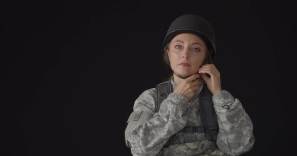 熟女兵士取るオフ彼女のヘルメット上の黒背景 — ストック動画