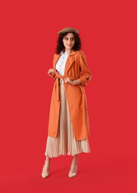 Kırmızı arka planda bereli şık Parisli kadın.