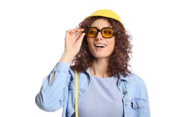 Şık güneş gözlüklü mutlu kadın beyaz arka planda kova şapka takıyor.