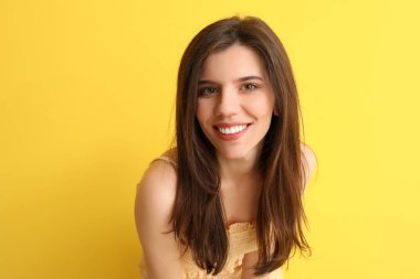 Renkli arka planda selfie çeken zarif genç bir kadın.