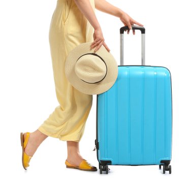 Beyaz arka planda şapkası ve çantası olan genç bir kadın.