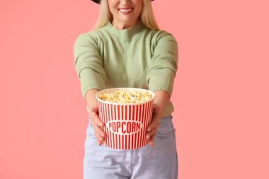 Renkli lezzetli patlamış mısırlı olgun bir kadın.