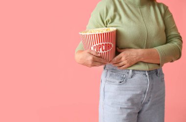 Renkli lezzetli patlamış mısırlı olgun bir kadın.