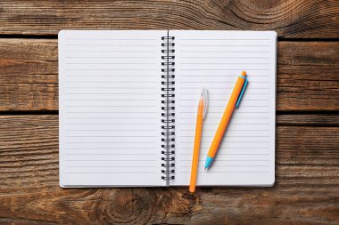 Ahşap zemin üzerinde defter ve kalemler