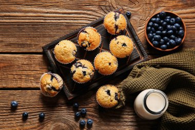 Lezzetli yaban mersinli kek, böğürtlen ve sütle ahşap zemin üzerinde kompozisyon