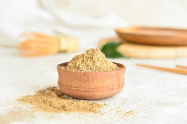 Açık arkaplanda hojicha pudrası olan kase