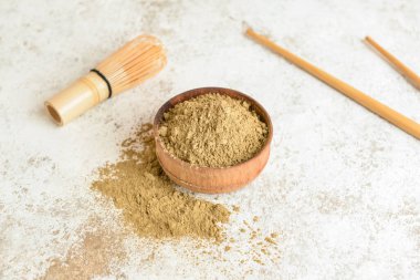 Açık arkaplanda hojicha pudrası olan kase