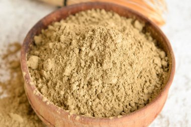 Arka planda hojicha pudrası olan kase, yakın plan.