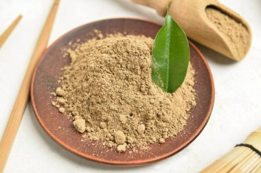 Beyaz arkaplanda hojicha pudrası olan plaka, yakın plan.