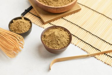 Beyaz arka planda hojicha pudrası olan kaseler