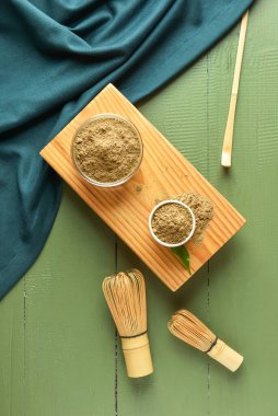 Yeşil ahşap arka planda hojicha tozu, chasen ve chashaku kaseleri