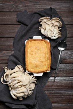 Siyah ahşap arka planda lezzetli mantarlı fırın yemeği.