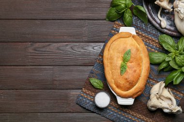 Lezzetli mantarlı kek ve siyah ahşap arka planda malzemeler.