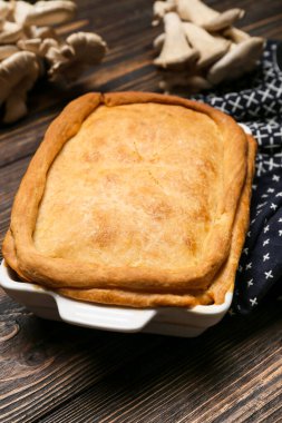 Ahşap zemin üzerinde lezzetli mantarlı turta pişirme tabağı