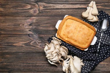 Ahşap zemin üzerinde lezzetli mantarlı turta pişirme tabağı