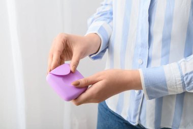 Kadın tampon depolamak için plastik kutu tutuyor, yakın plan.