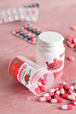 Renkli arka planda kızılcık hapları şişeleri