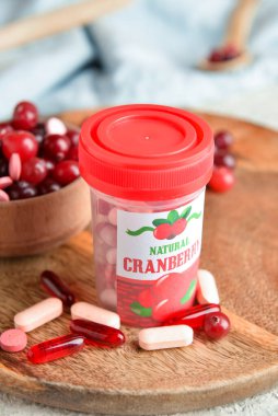 Ahşap tepside bir şişe yabanmersini hapı.