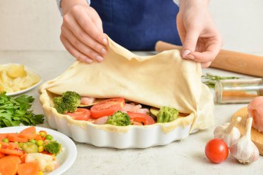 Mutfak masasında sebzeli tavuk turtası hazırlayan kadın, yakın plan.